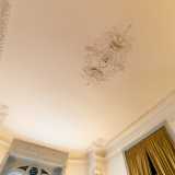 Il soffitto e le pareti sono arricchiti infatti da stucchi in gesso e fini cornici perimetrali con fantasie vegetali...